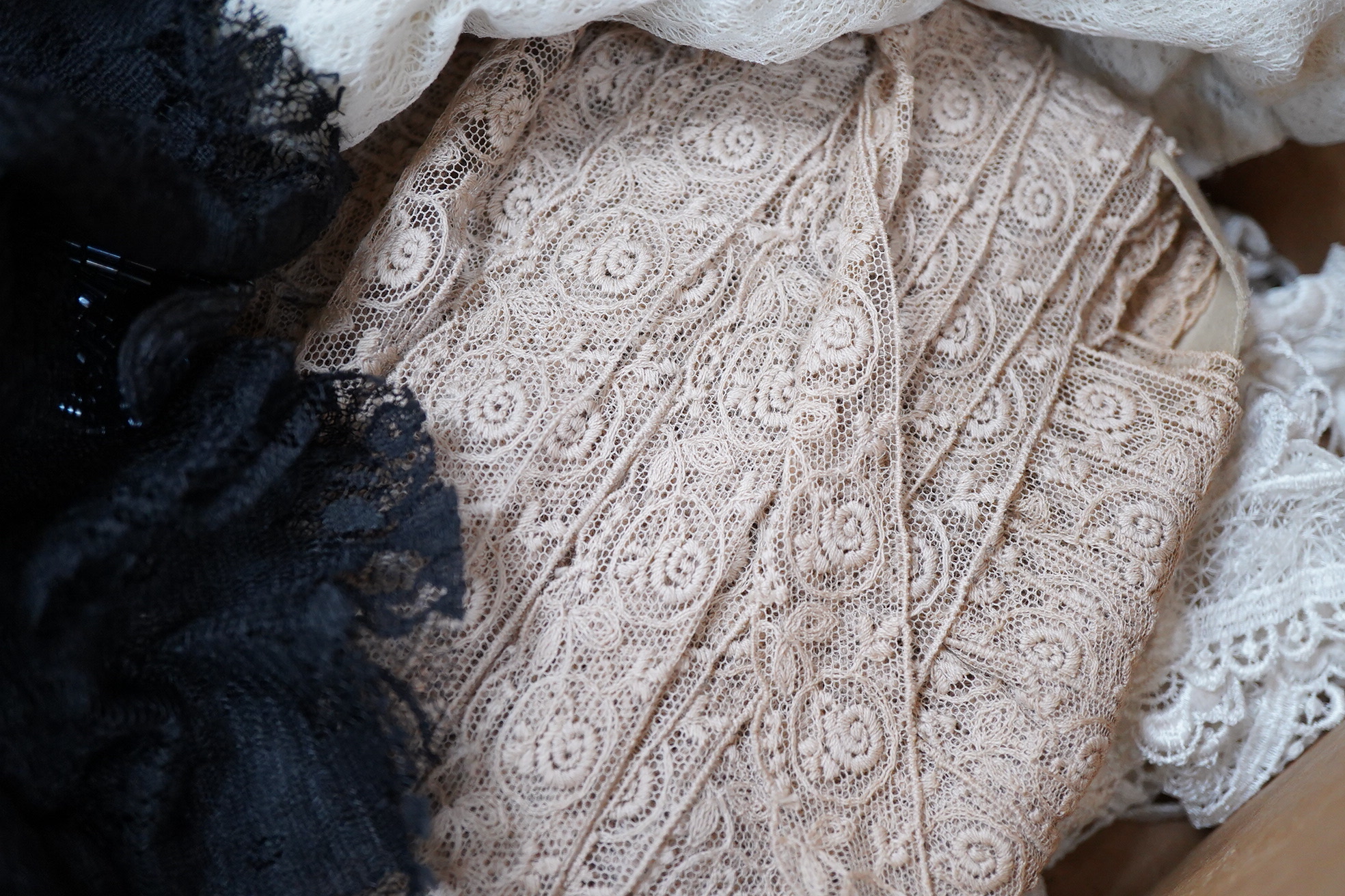 A collection of lace including black and coloured lace panels, mostly machine lace
